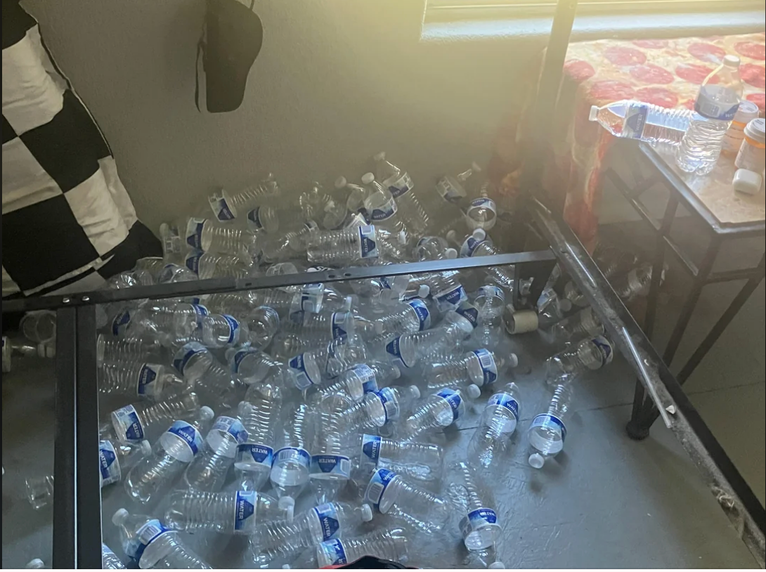 Dozens of bare integrative h2o bottles are scattered connected the level nether a furniture framework successful a cluttered room