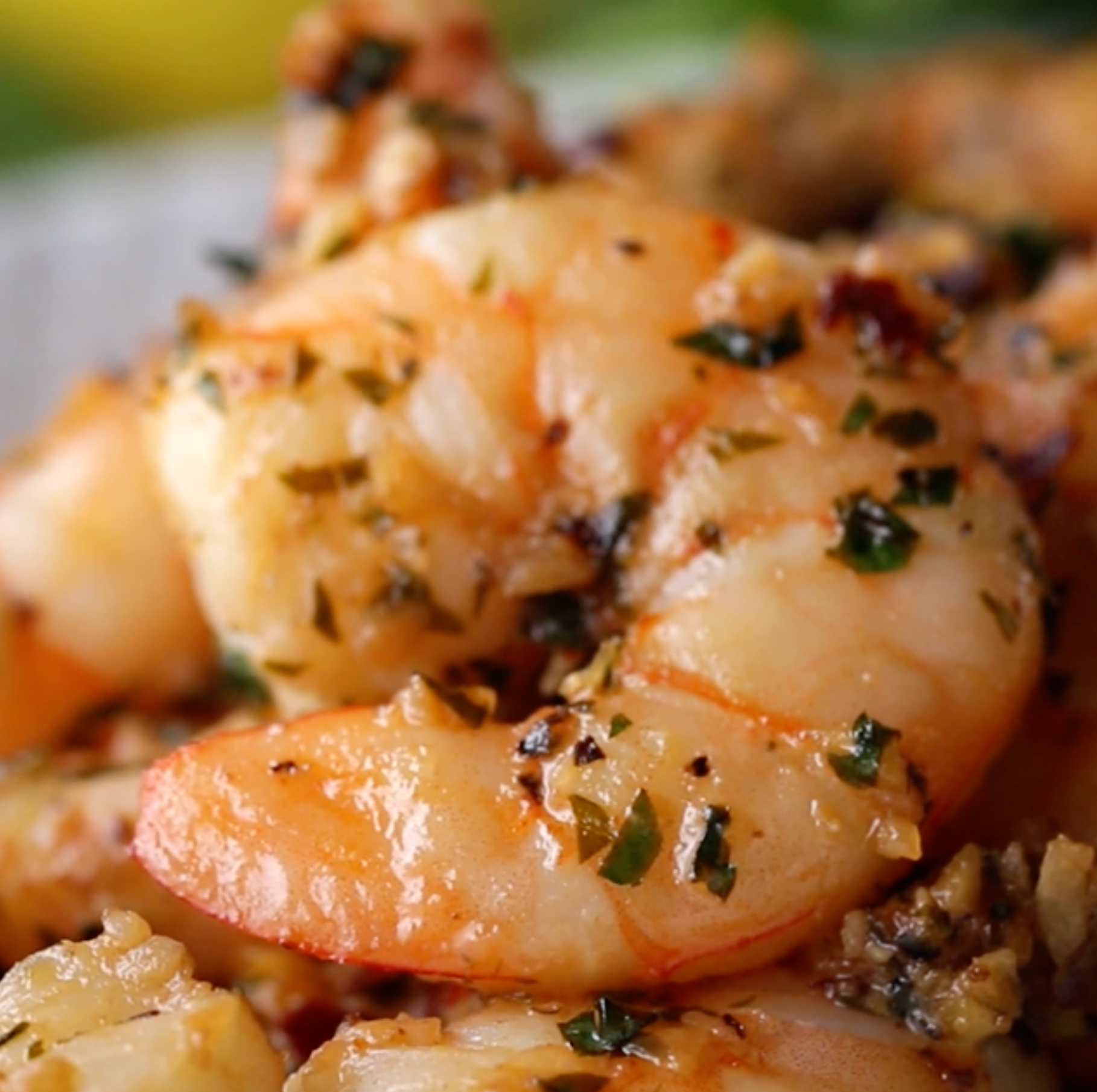 Close-up of cooked shrimp seasoned with herbs and spices, glistening with a savory glaze, capturing a delicious, appetizing appearance