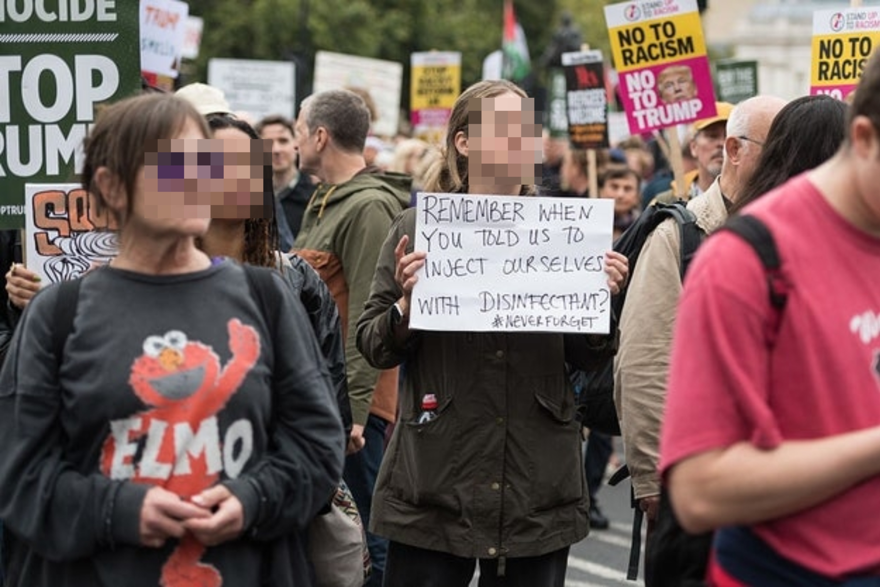 Folk som protesterer med skilt, inkludert en som leser 