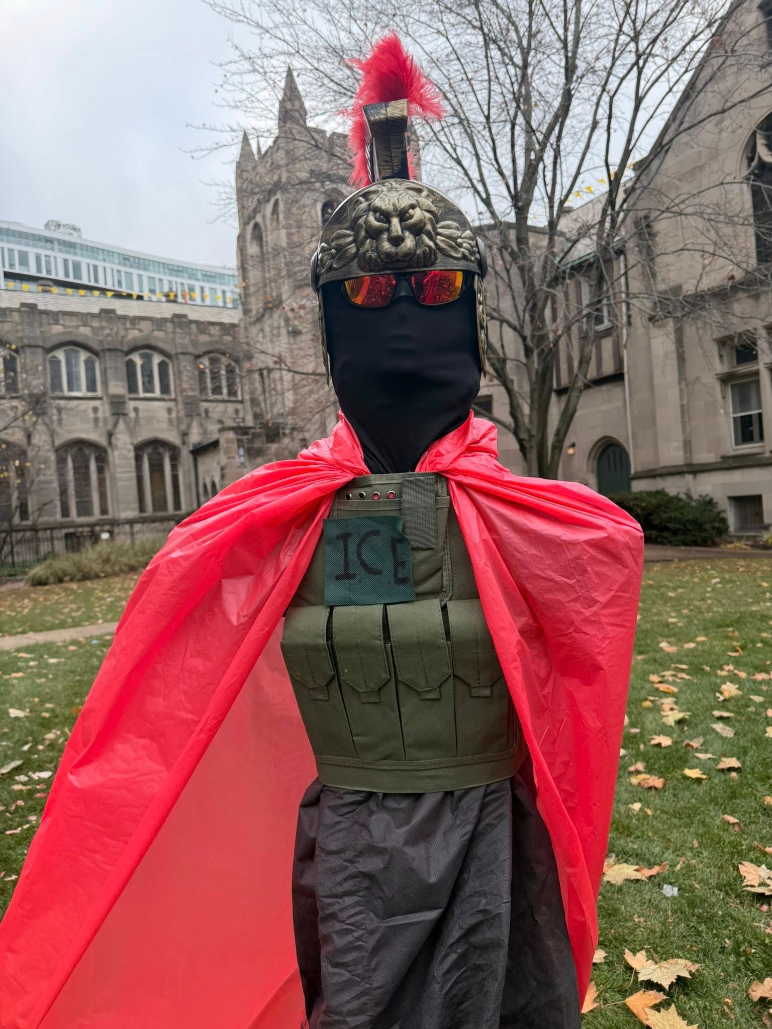 Statue kledd som en romersk soldat med løvehjelm, rød kappe og vest merket 