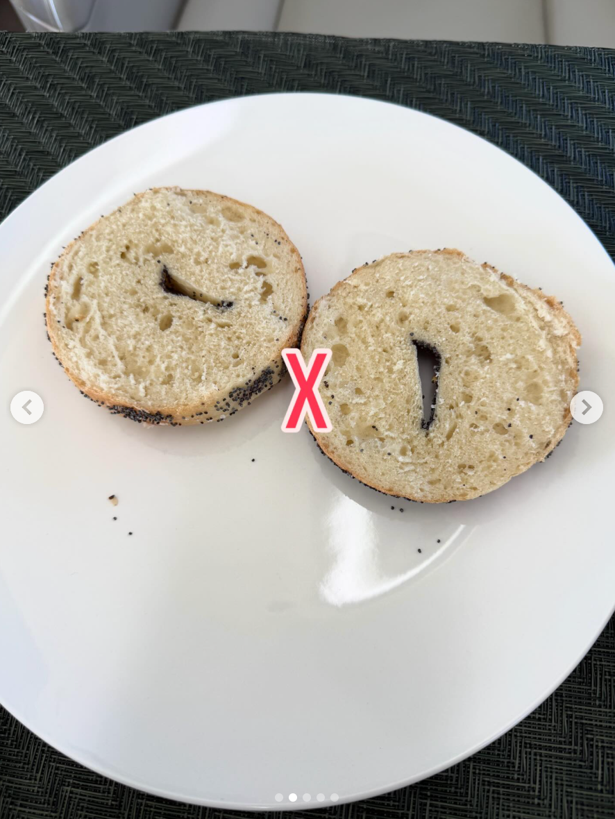 Bagel sliced unevenly on a plate, showing a large "X" mark emphasizing the uneven cut