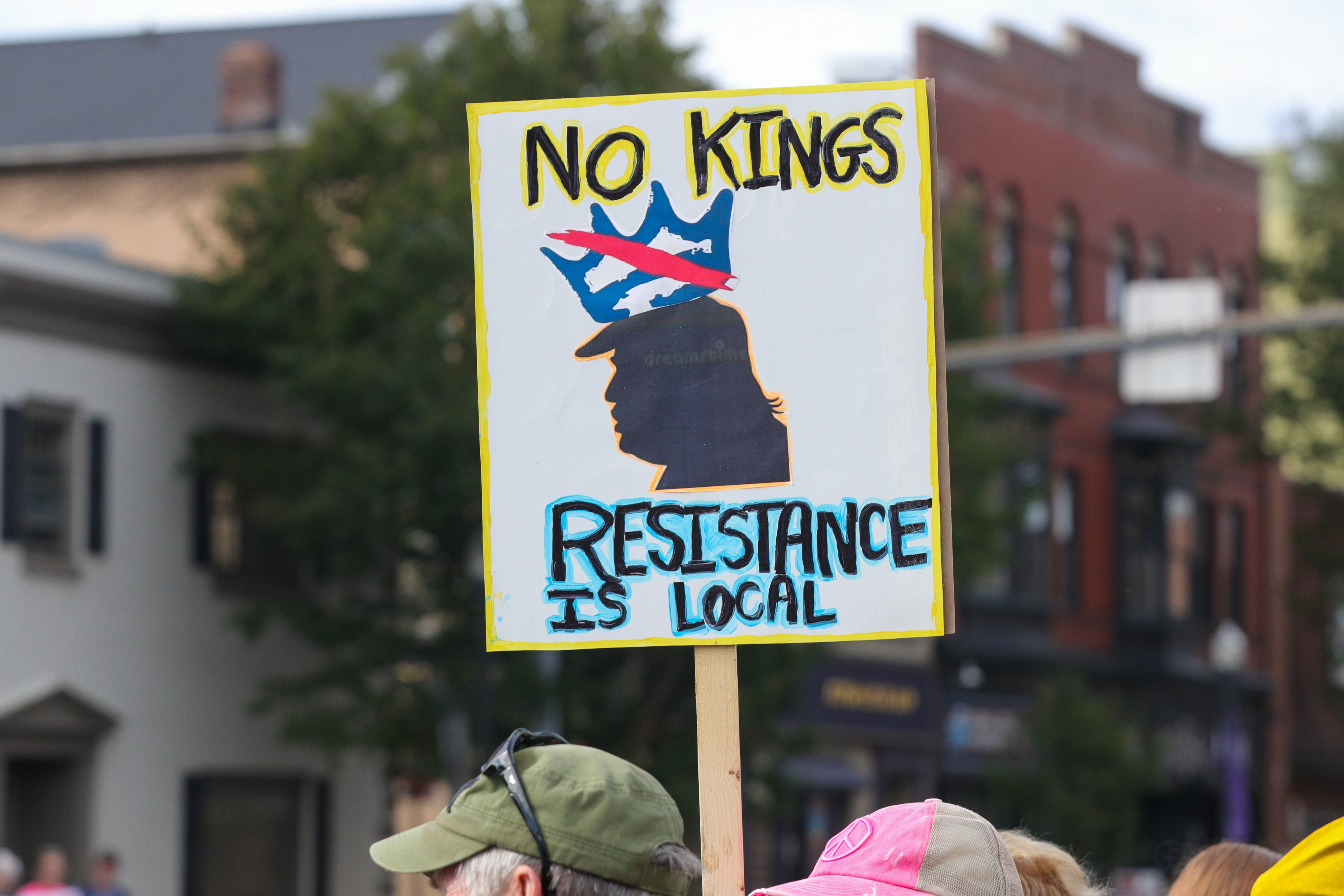 Demonstranten holder et skilt med en silhuett iført en krone og teksten: