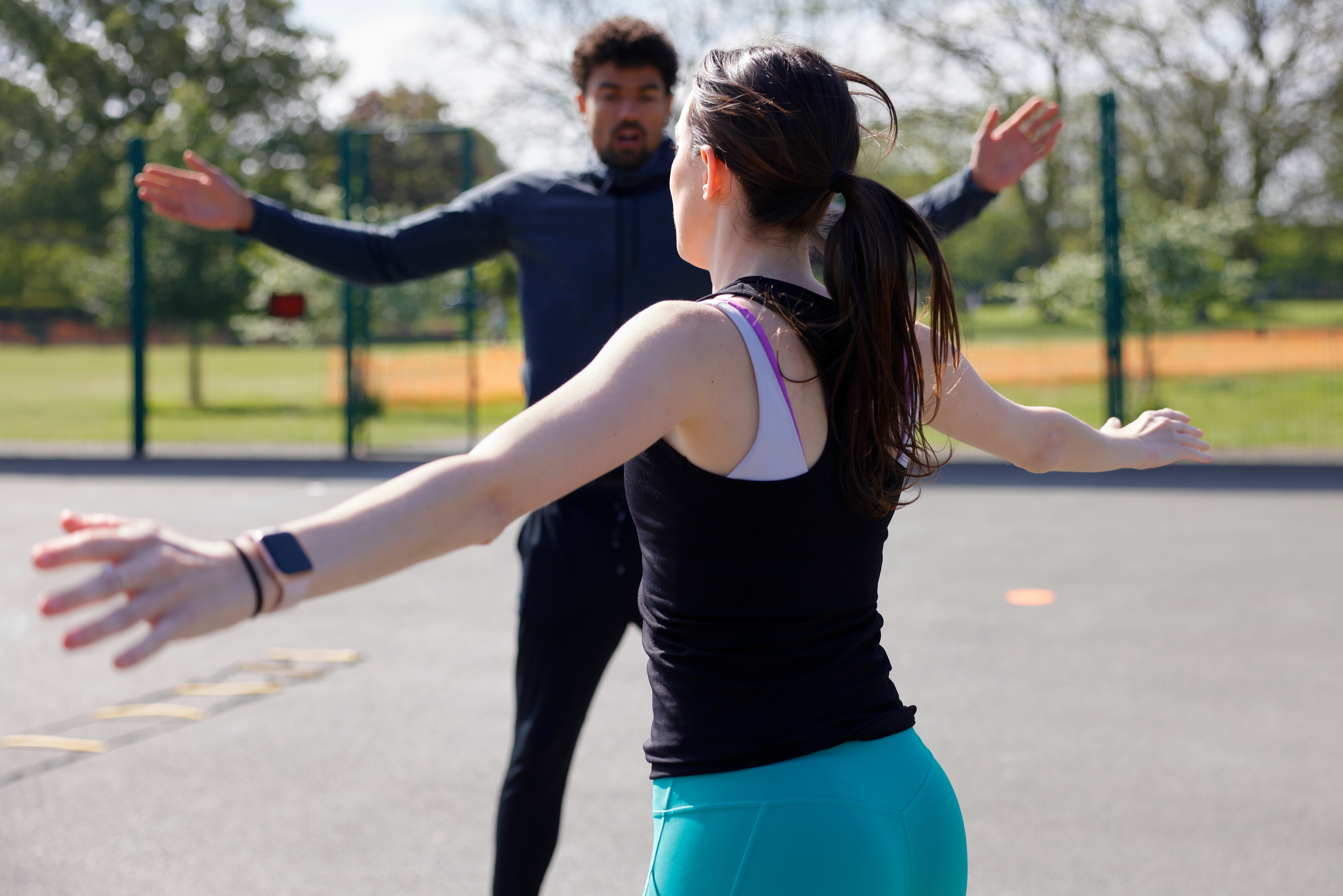 Two radical exercising outdoors with arms outstretched, focusing connected a fittingness regular successful a parkland environment