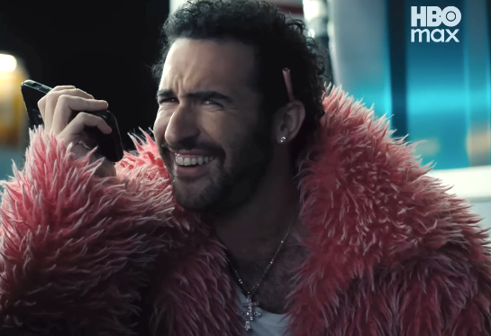 Person smiling portion talking connected a phone. They are wearing a fluffy overgarment and person an earring. HBO Max logo disposable successful the corner