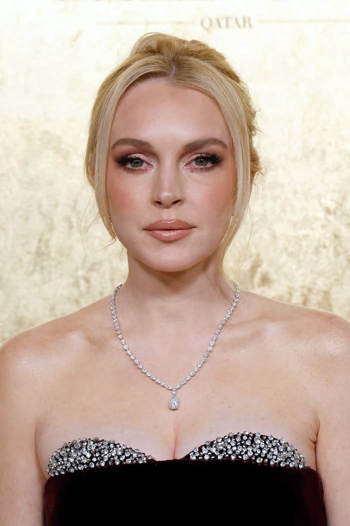 Lindsay Lohan wearing an elegant strapless gown with metallic  embellishments and a diamond necklace astatine  a ceremonial  event