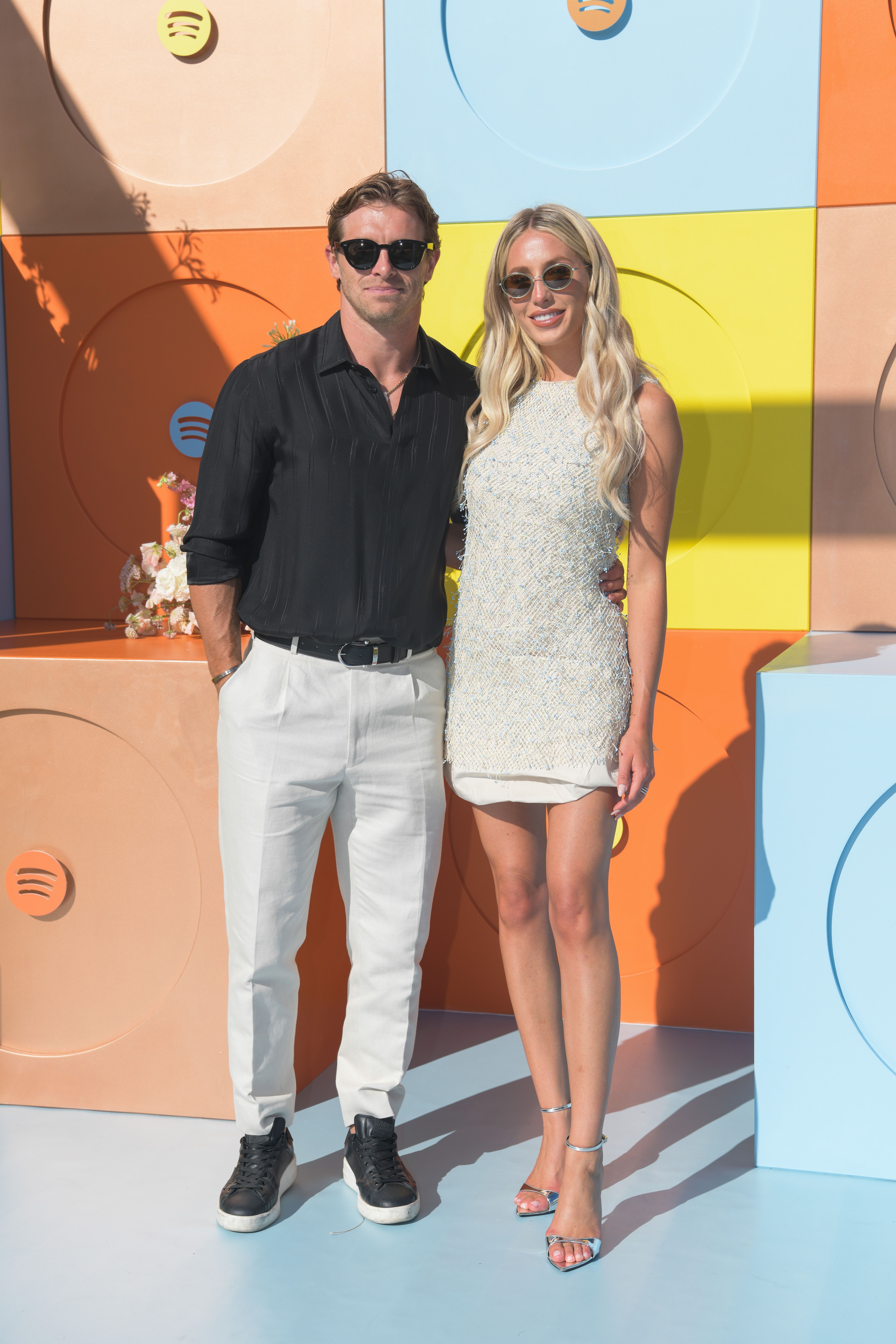 Braxton Berrios and Alix Earle airs for a photograph astatine an event. The antheral wears a achromatic garment and achromatic pants; the pistillate wears a sleeveless formal and sunglasses