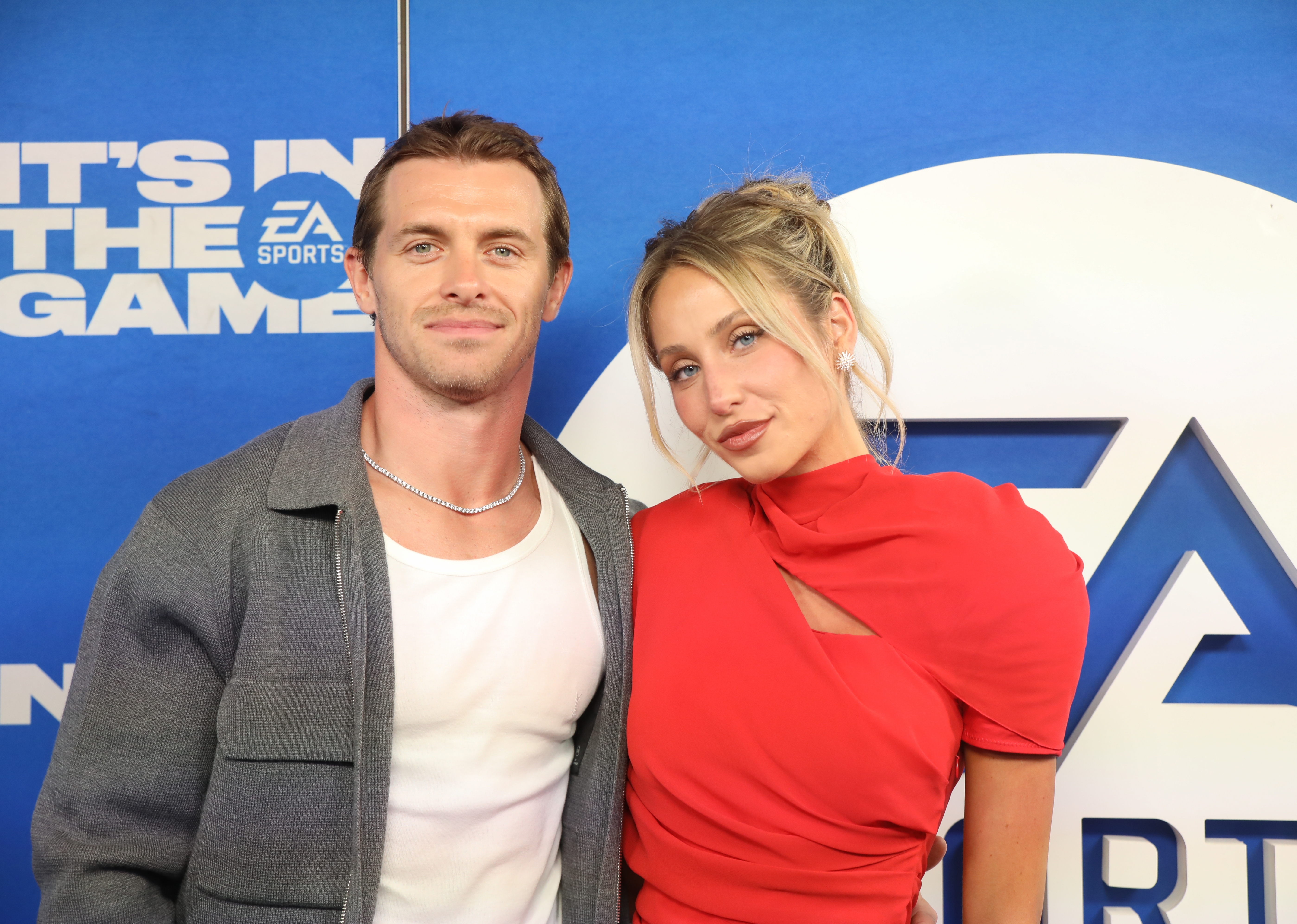 Alix Earle and Braxton Berrios airs unneurotic astatine a media event. One wears a casual overgarment implicit a T-shirt, and the different wears a stylish reddish outfit