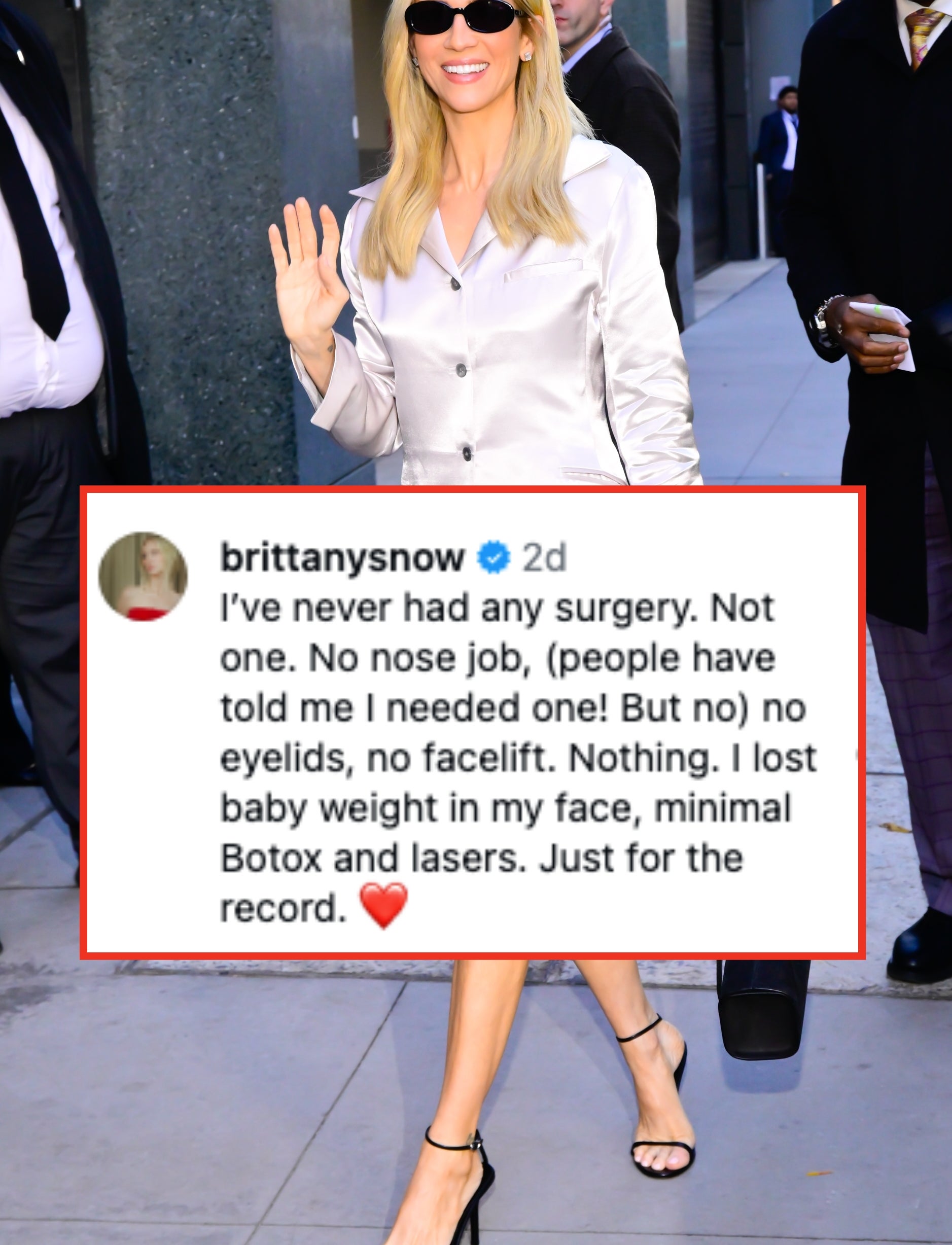 Celebrity successful a sleek, shiny blazer formal and sunglasses, waving and smiling portion holding a achromatic handbag connected a metropolis street