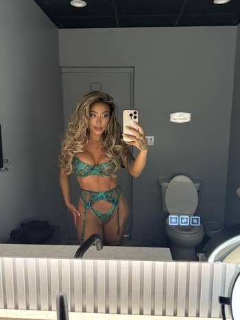 Person taking a reflector selfie successful a revealing outfit with elaborate design, lasting successful a bathroom