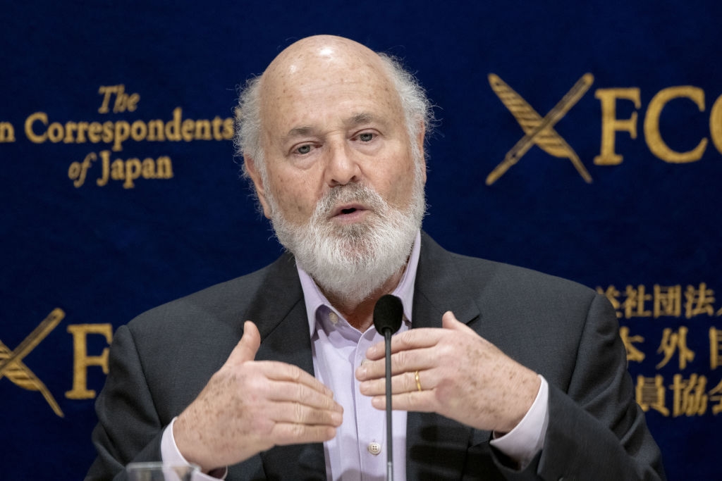 Mann som snakker på en pressebegivenhet, gestikulerer med hendene nær et podium mot utenrikskorrespondentene' Club of Japan