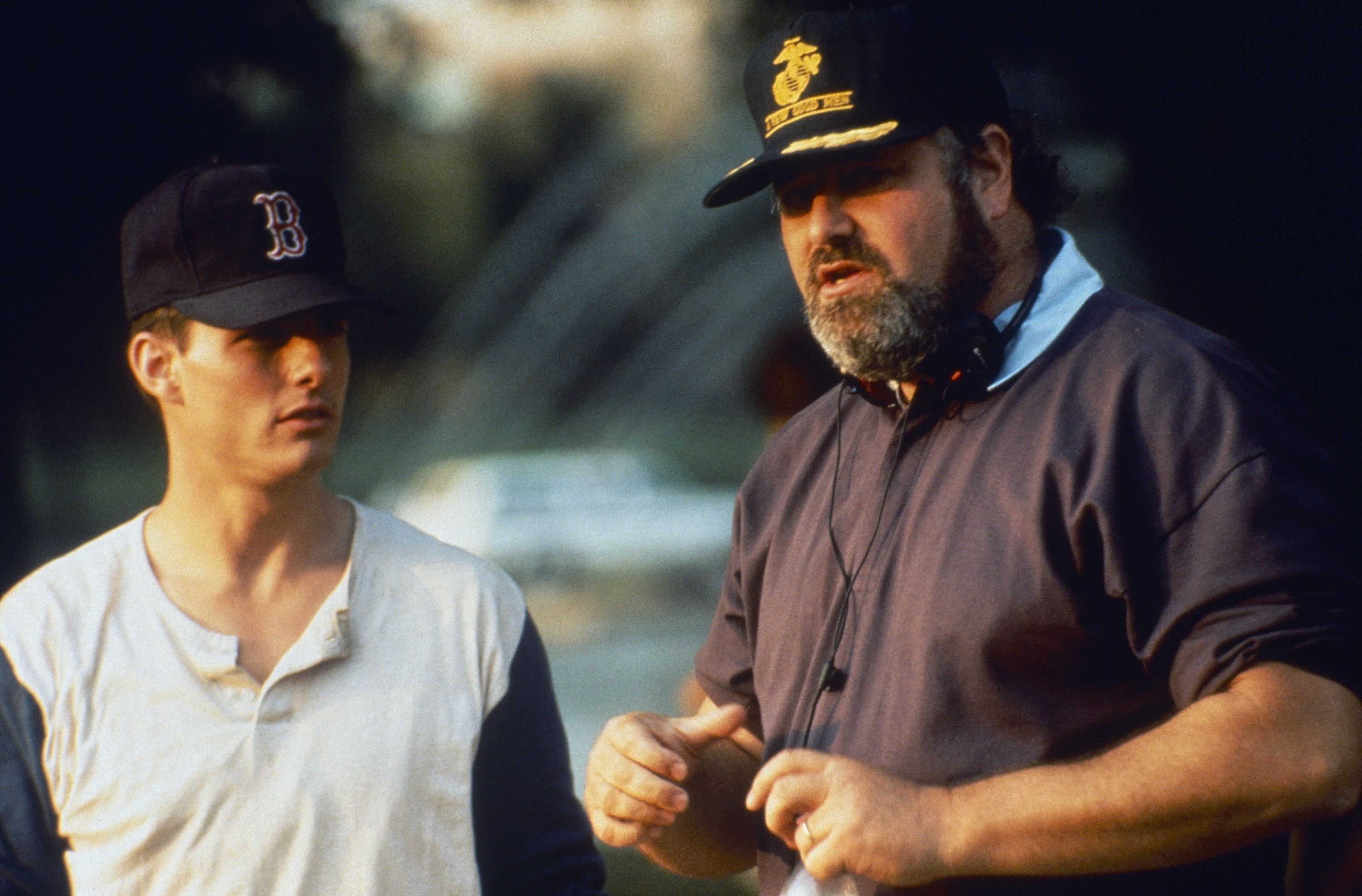 Two radical are having a speech outdoors; 1 wears a shot headdress and casual shirt, the different wears a headdress and sweatshirt, gesturing arsenic helium talks