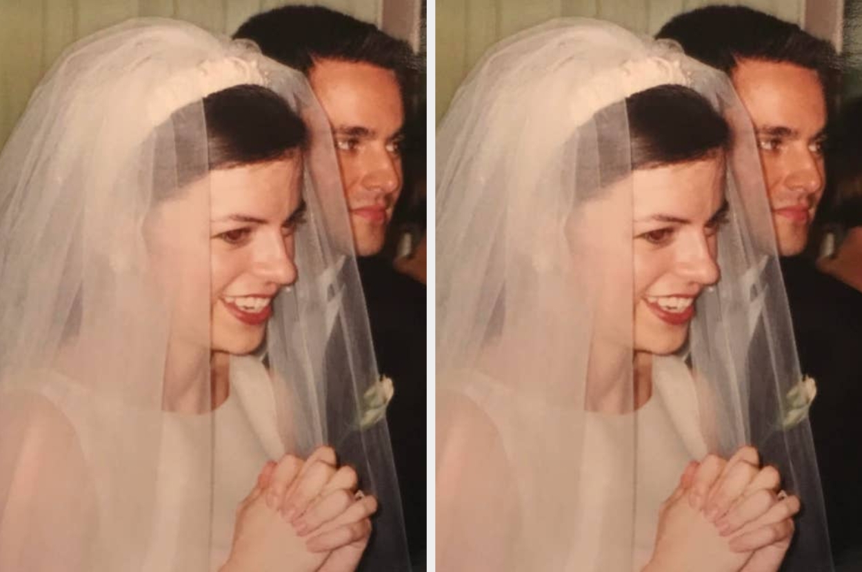 A bride in a wedding dress, smiling with hands clasped, stands next to a man in a suit, both appearing joyful