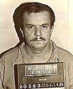 A man holding a prison identification sign from the Nevada Department of Prisons