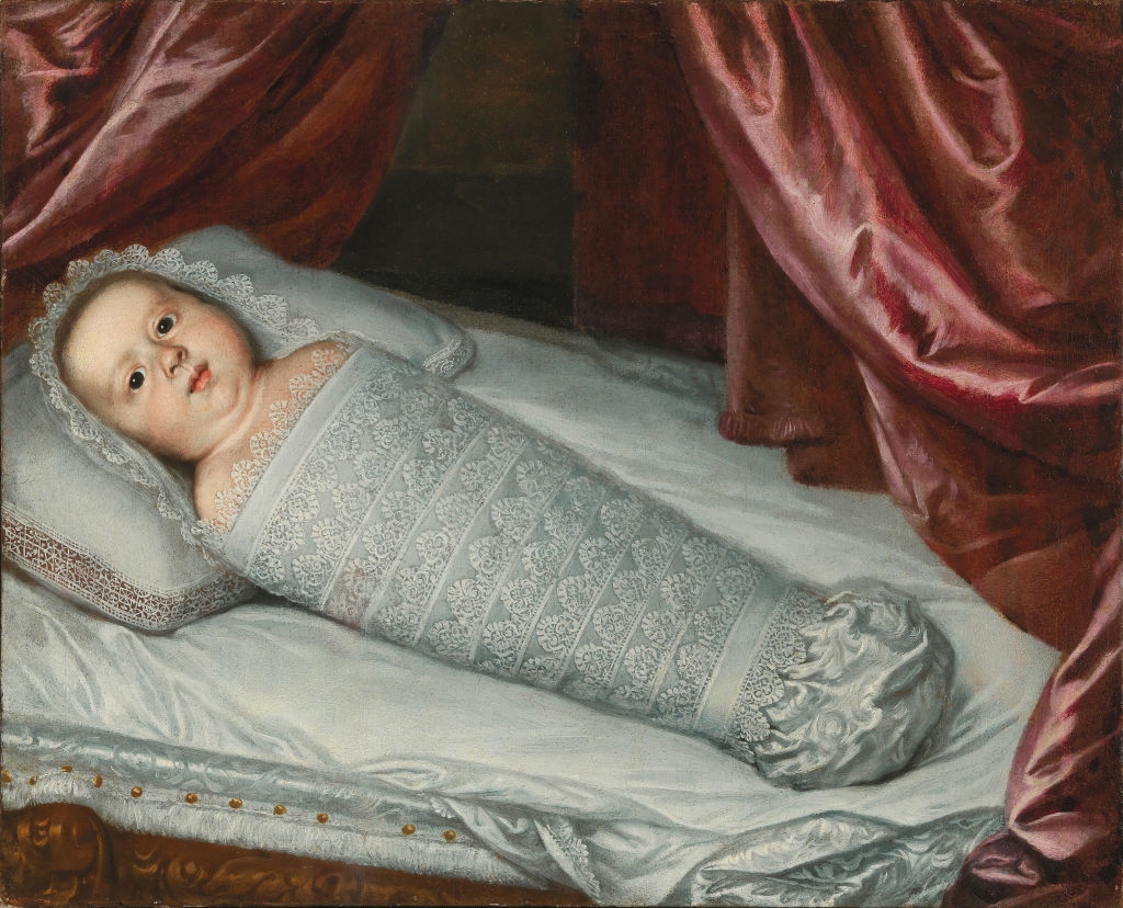 A babe  wrapped successful  ornate lace swaddling lies connected  a bed, surrounded by luxurious curtains