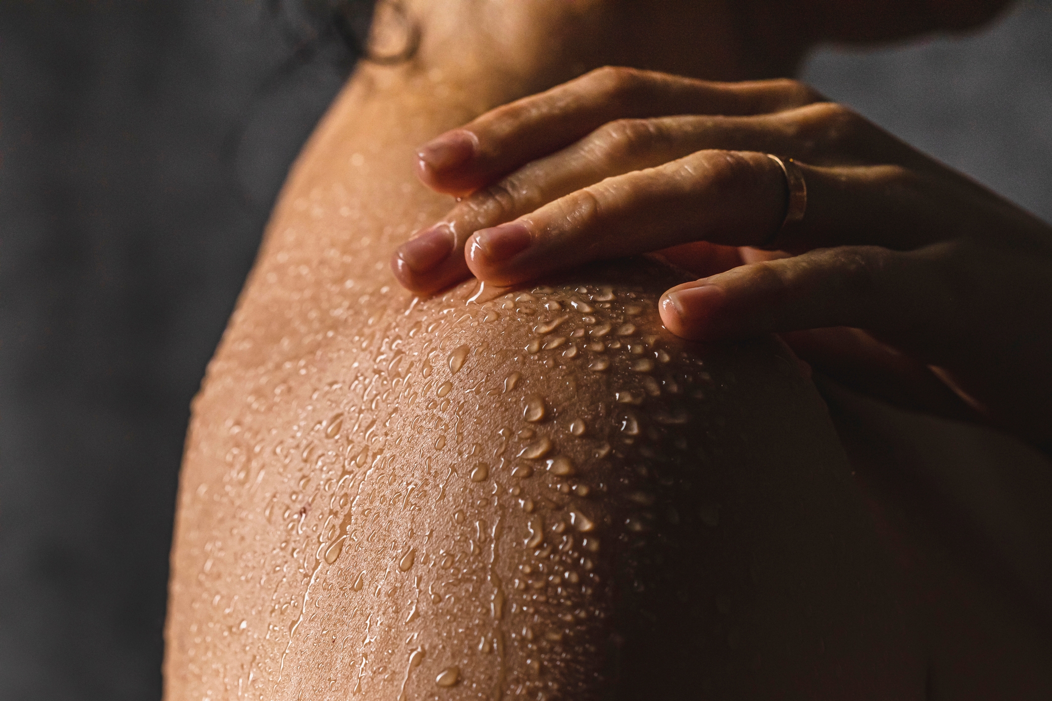Close-up of a person's enarthrosis and manus with h2o droplets connected the skin, conveying a refreshing and soothing moment