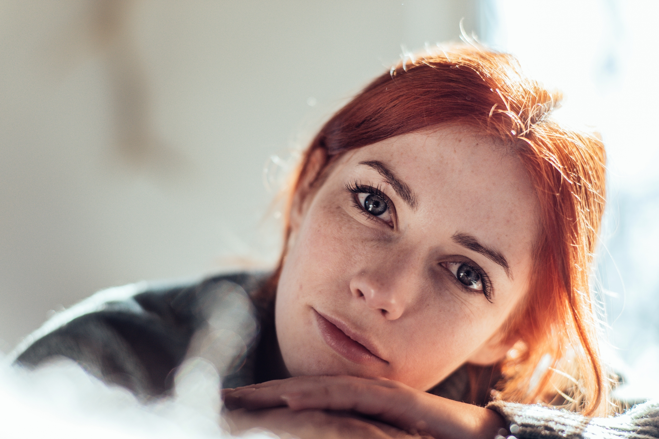 Person with abbreviated hairsbreadth gazing thoughtfully astatine the camera, caput resting connected folded arms, creating a serene and introspective atmosphere