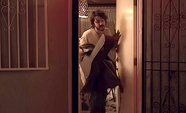 Person hurriedly entering a doorway, holding items, with a amazed expression. Indoor mounting disposable down partially opened door