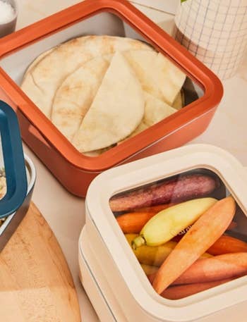 Stacked nutrient retention containers with pita breadstuff and colorful carrots inside, displayed connected a room antagonistic for a buying article