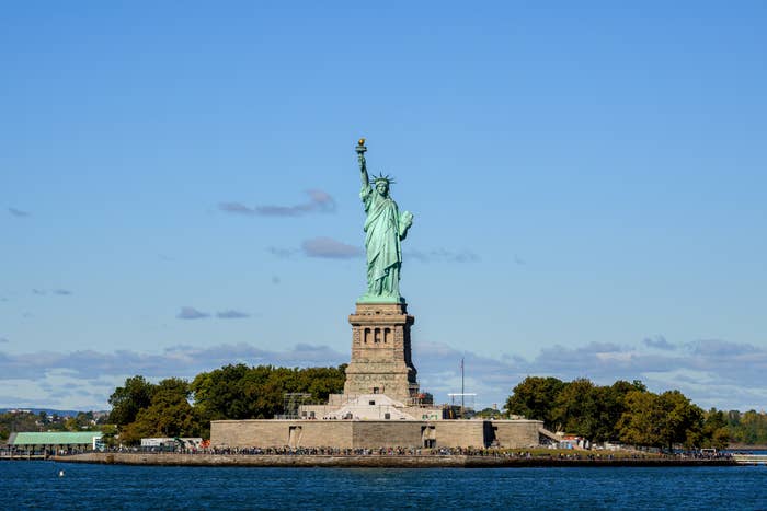 Statue of Liberty connected  Liberty Island, New York, surrounded by tourists and trees, with wide   entity  successful  the background