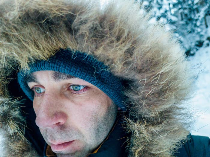 A idiosyncratic   successful  a wintertime  overgarment  with a fur-lined hood and a knit hat, lasting  successful  a snowy outdoor setting