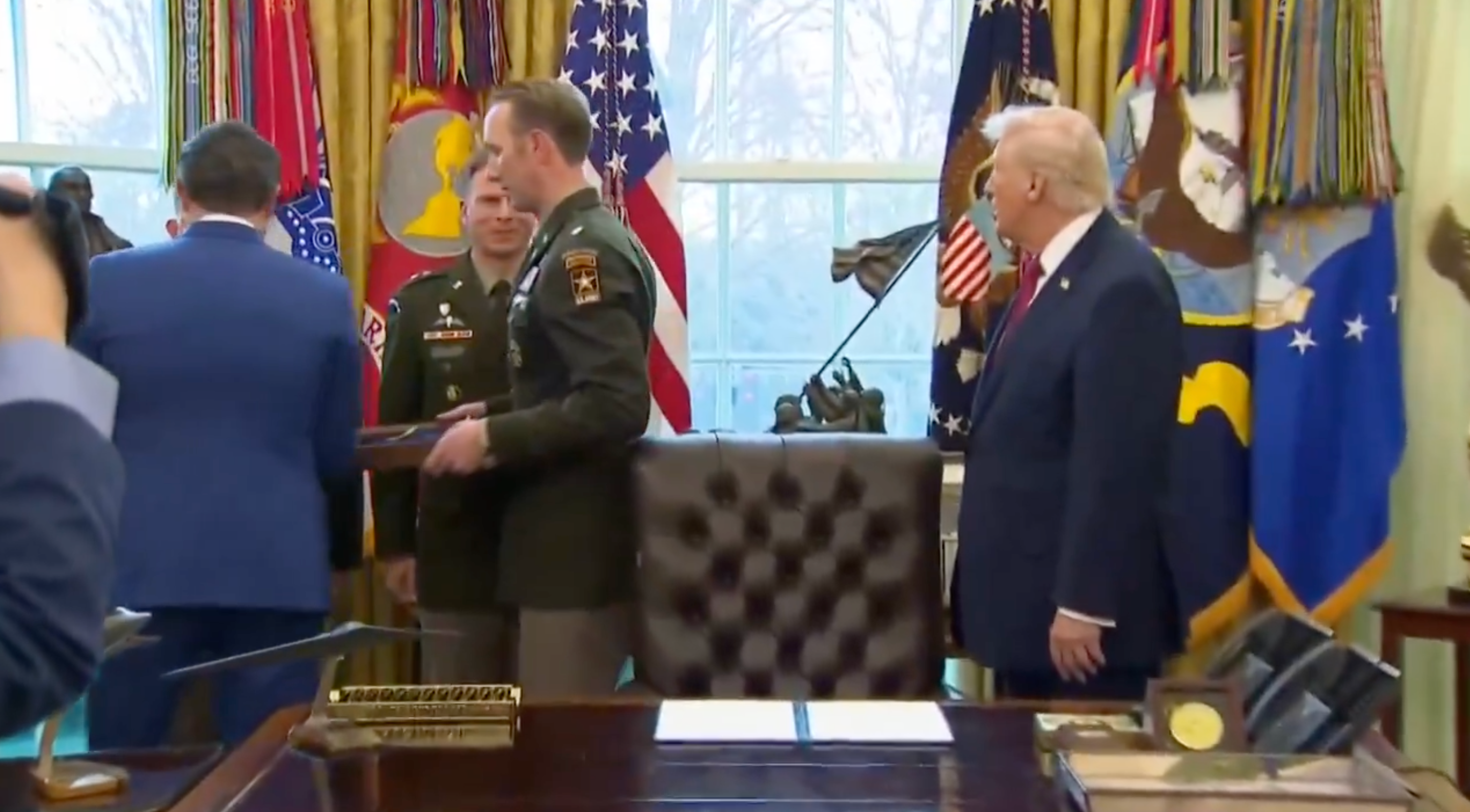 Public fig with subject unit successful an bureau setting, discussing and interacting adjacent a table with flags displayed successful the background