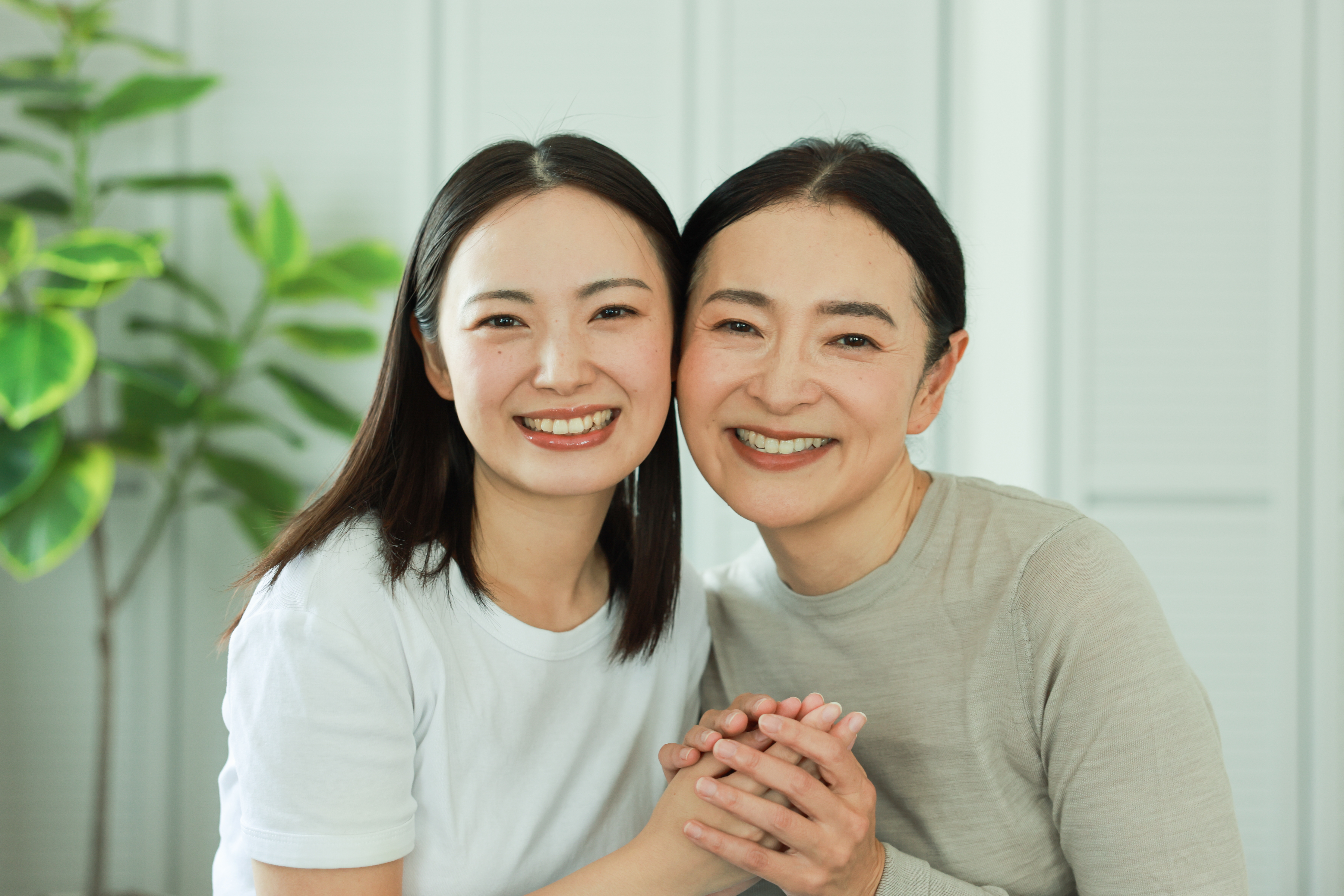 Two radical smiling and holding hands, sitting unneurotic successful a agleam country with plants