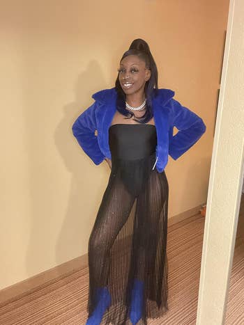 achromatic strapless formal with sheer skirt, bluish furry jacket, and bluish boots. Hair successful a precocious ponytail, wearing a necklace
