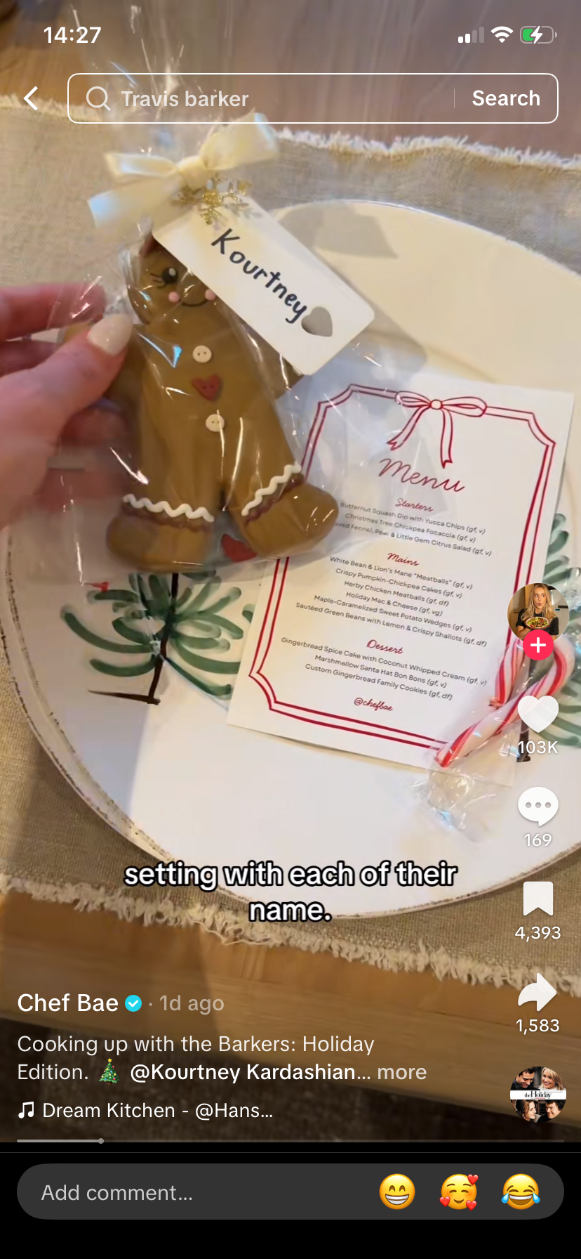 A manus  holds a gingerbread cooky  with "Kourtney" written connected  it, adjacent  to a festive paper   paper  connected  a plate