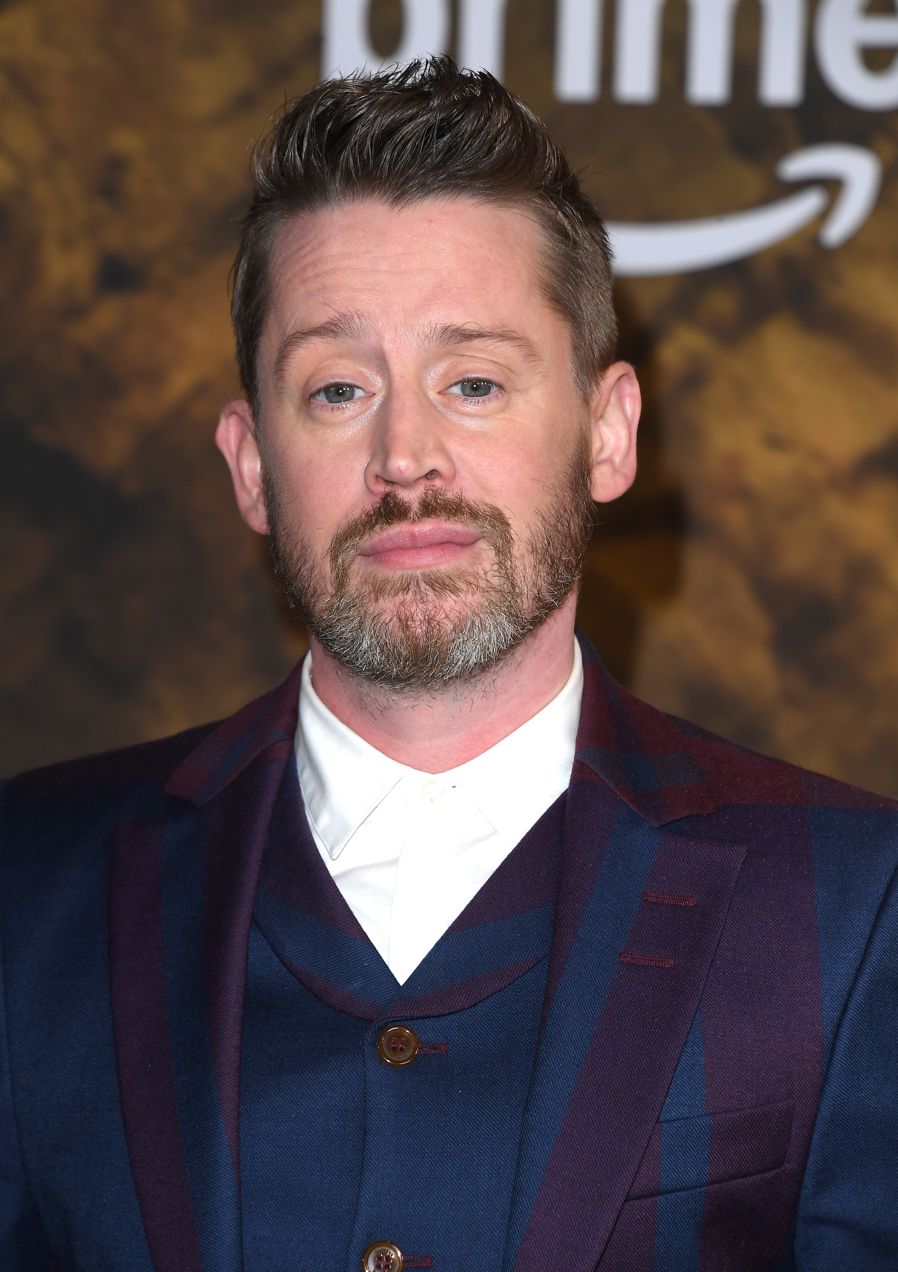 Person successful  a suit   with a neatly groomed beard and styled hairsbreadth  lasting  astatine  an lawsuit   backdrop