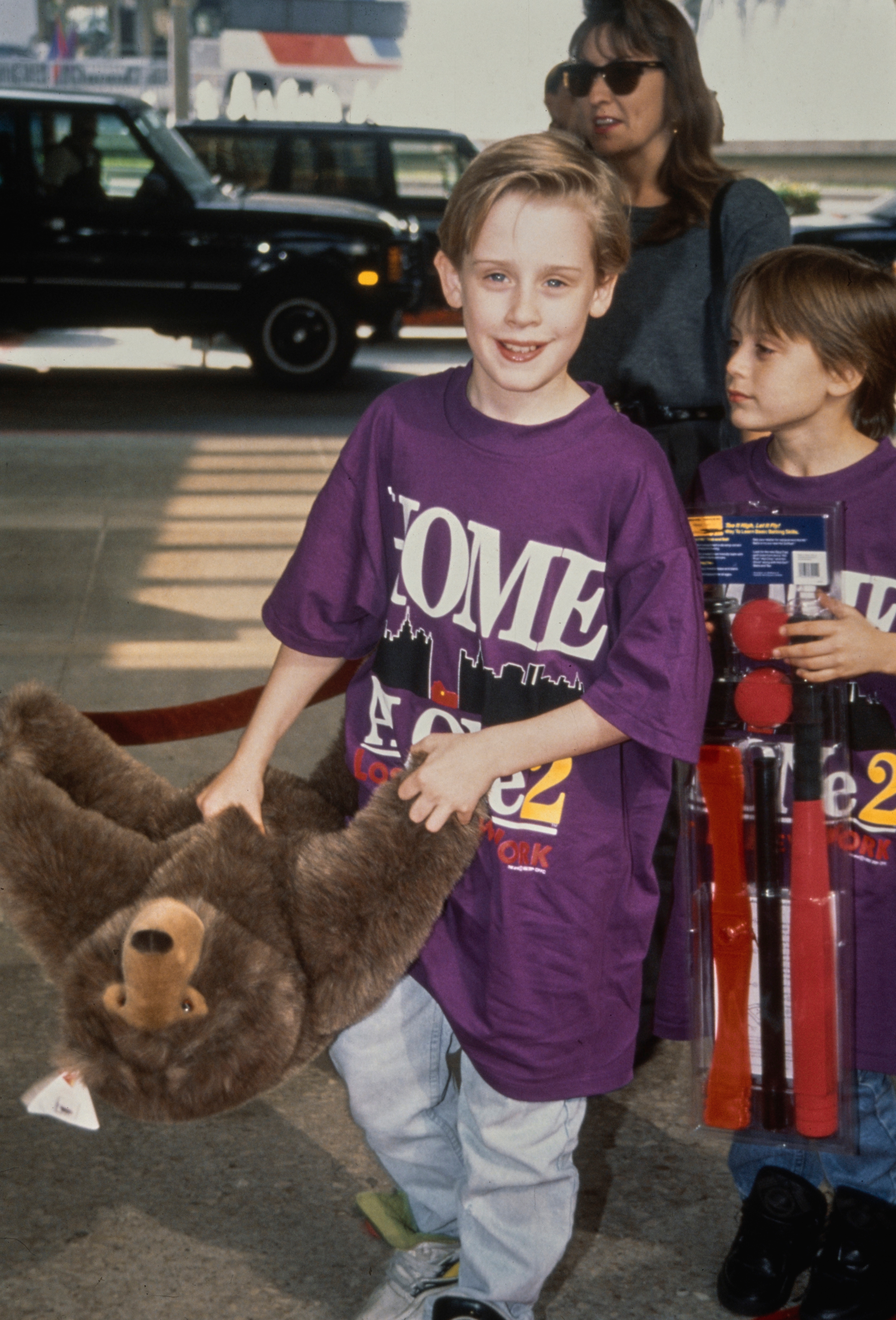 A kid  holding a teddy carnivore  and accompanied by different  kid  with toys astatine  a nationalist   event