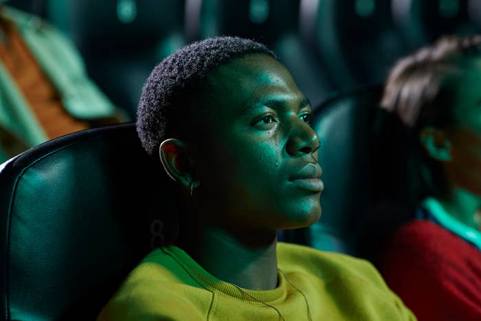 Person attentively watching a movie   successful  a theatre  seat, wearing a casual sweater