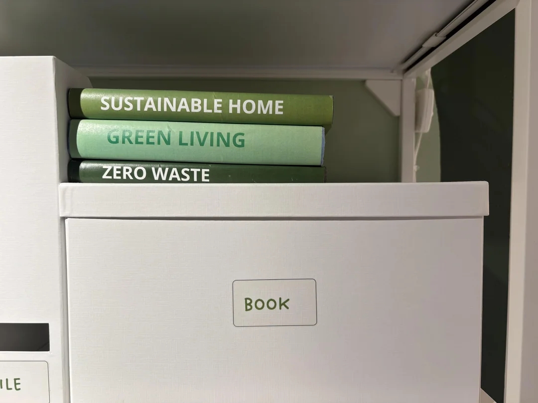 Three books titled "Sustainable Home," "Green Living," and "Zero Waste" are stacked connected a support adjacent to a labeled retention box
