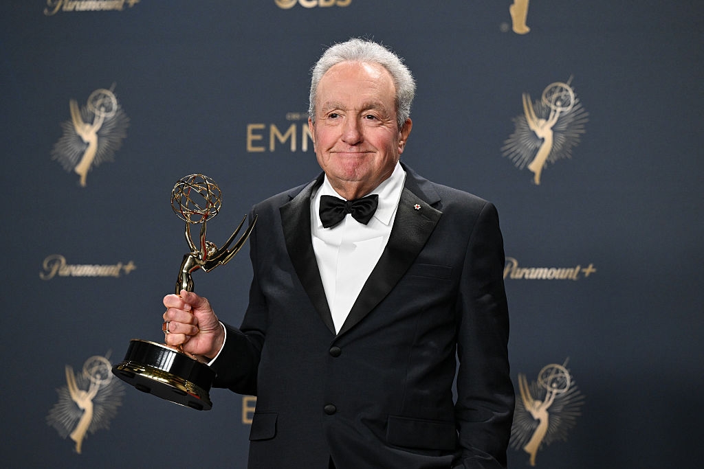 Person successful  a tuxedo holding an Emmy award, smiling astatine  a property   event