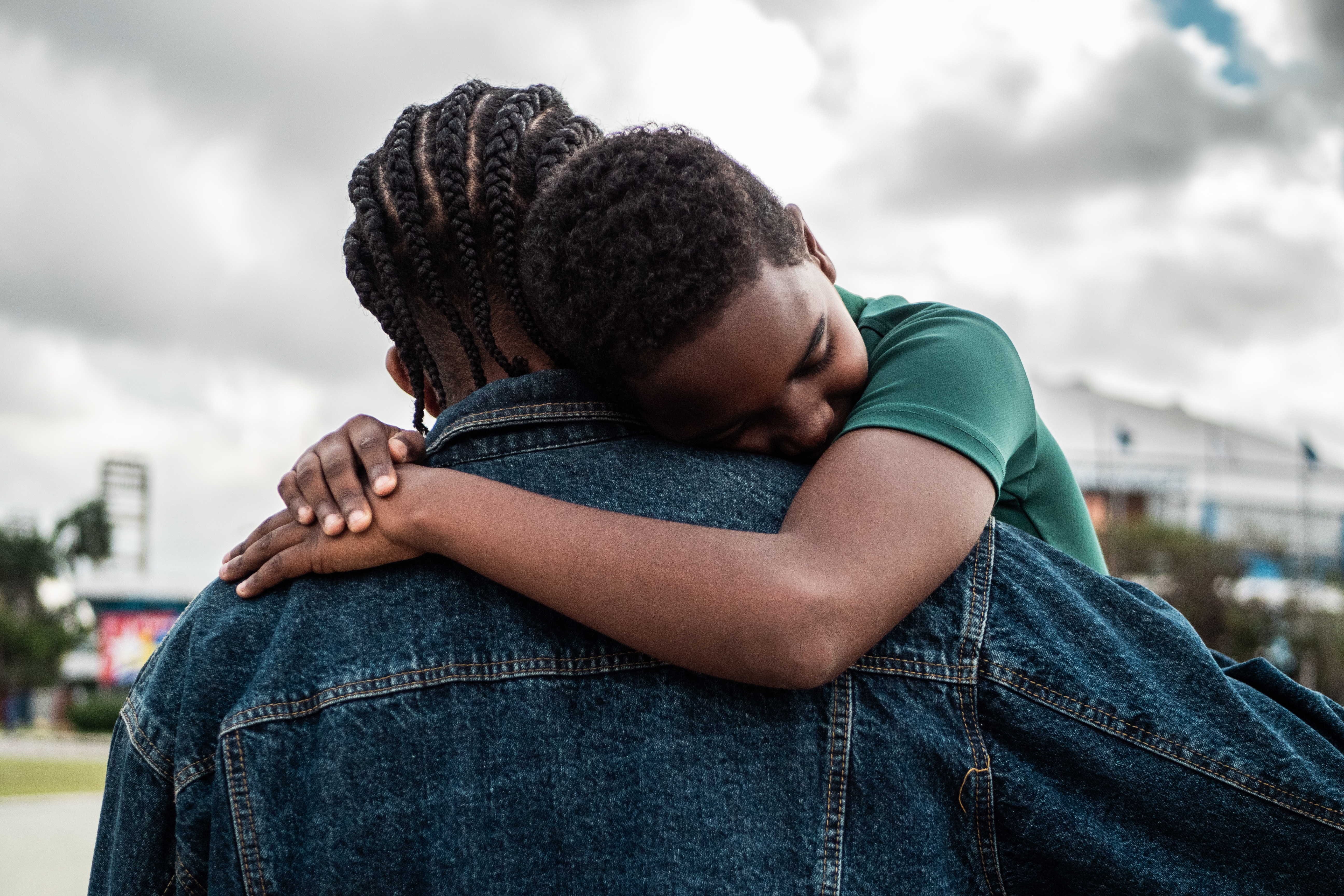 Child rests peacefully connected  adult's enarthrosis  successful  an outdoor setting, conveying a consciousness   of comfortableness  and trust