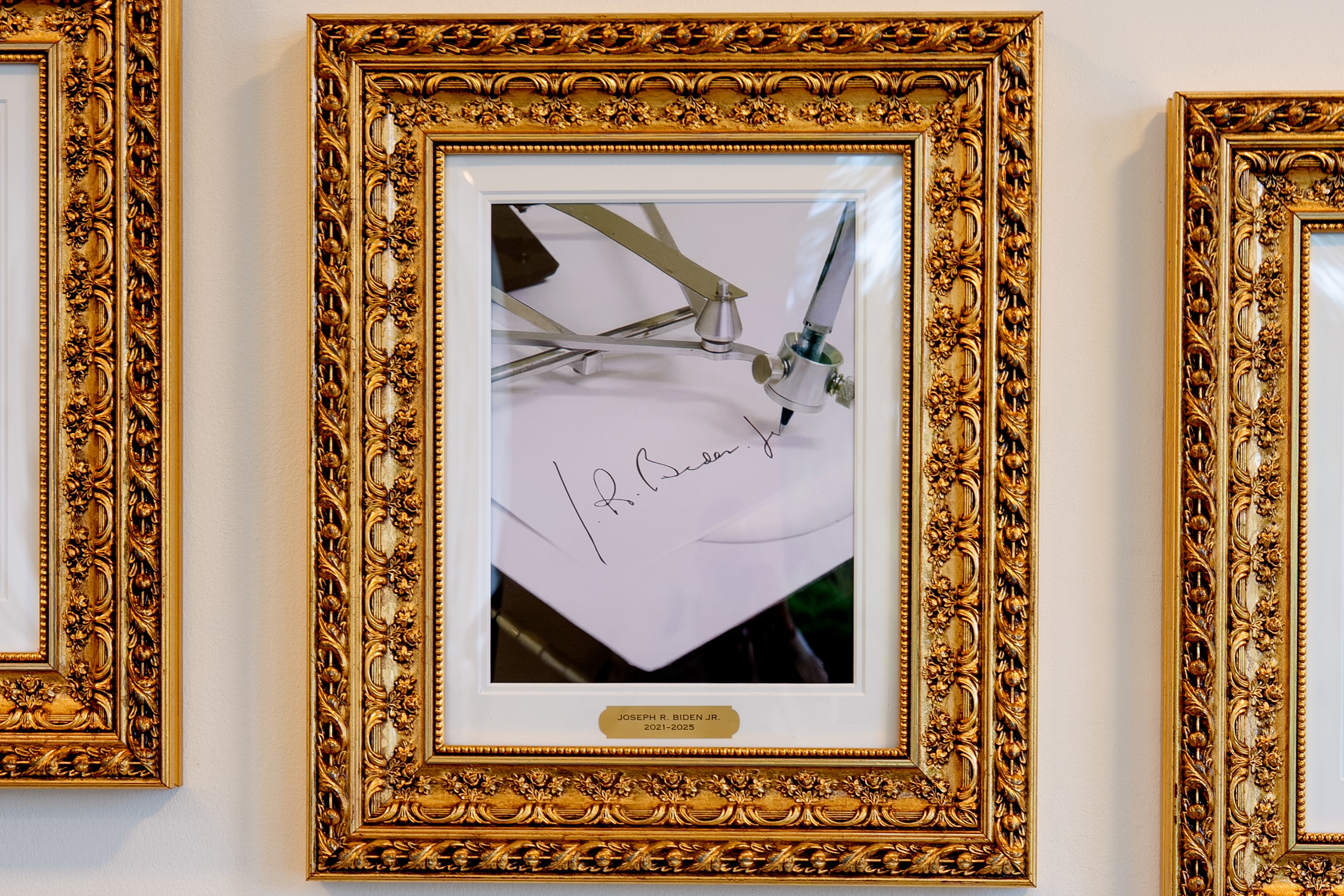 Intrikat innrammet bilde av en robotarm som signerer et papir, merket 