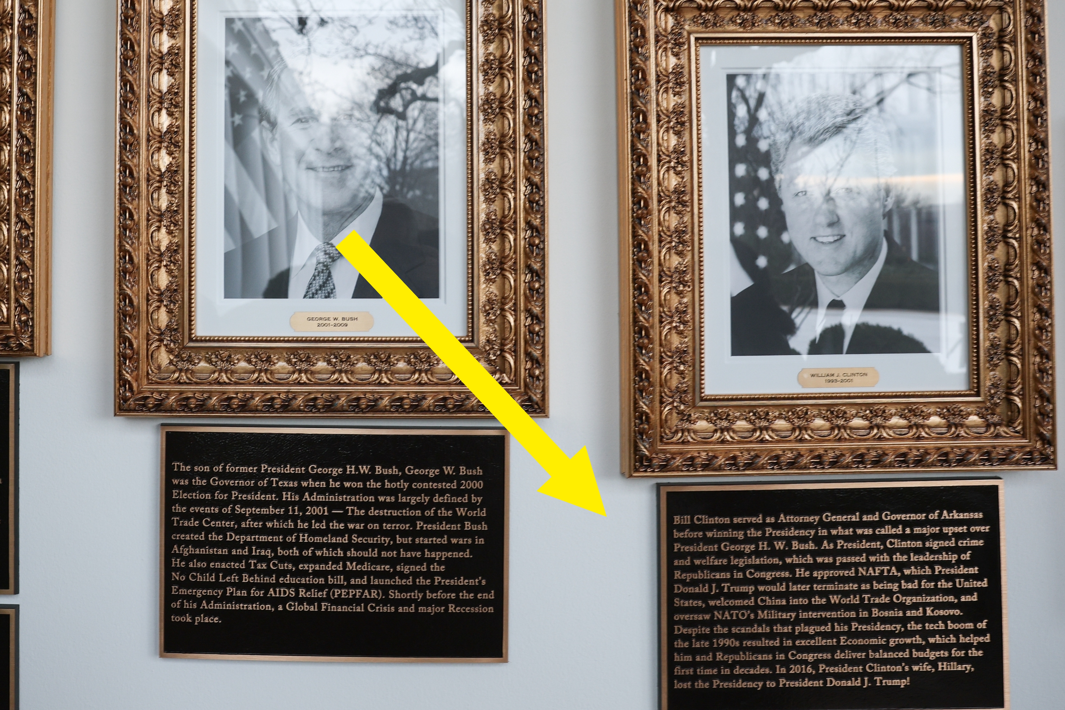 Tre innrammede svart-hvitt-portretter av amerikanske ledere med plaketter under som beskriver deres prestasjoner på en vegg