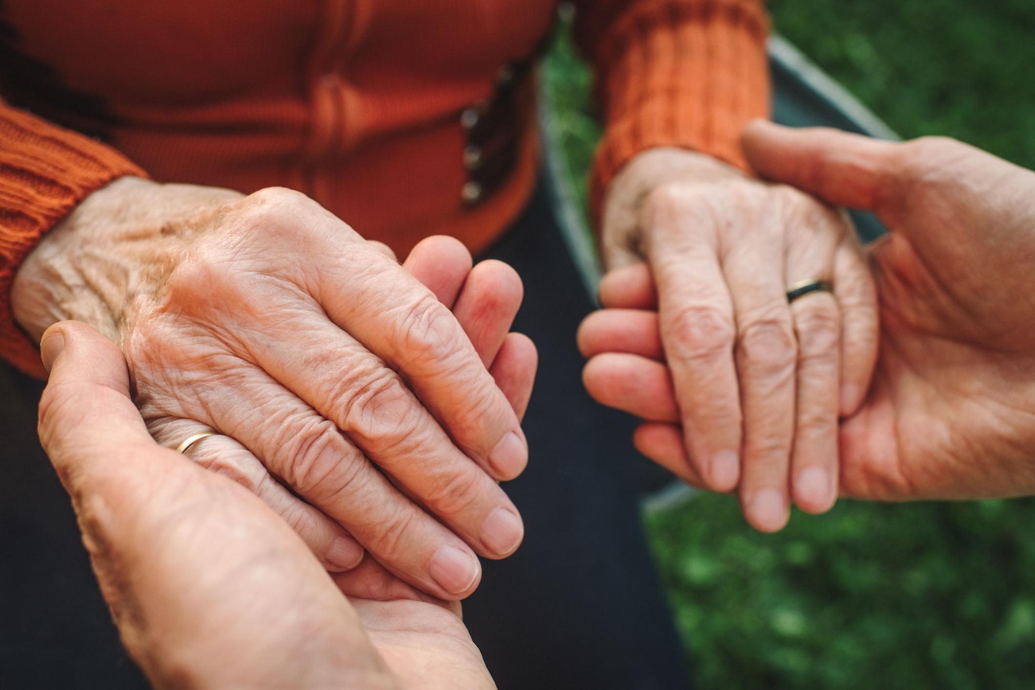 Two pairs of hands holding each   different   gently, symbolizing enactment    and care