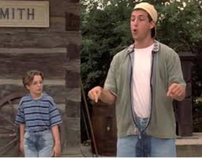 A antheral   successful  casual attire talks animatedly extracurricular  with a young lad  wearing a striped shirt, some  successful  beforehand   of a rustic building