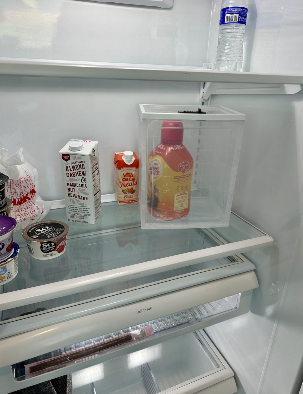 Refrigerator shelves with almond milk, yogurt, a vitamin C drink, and juice. Water vessel  connected  apical  shelf
