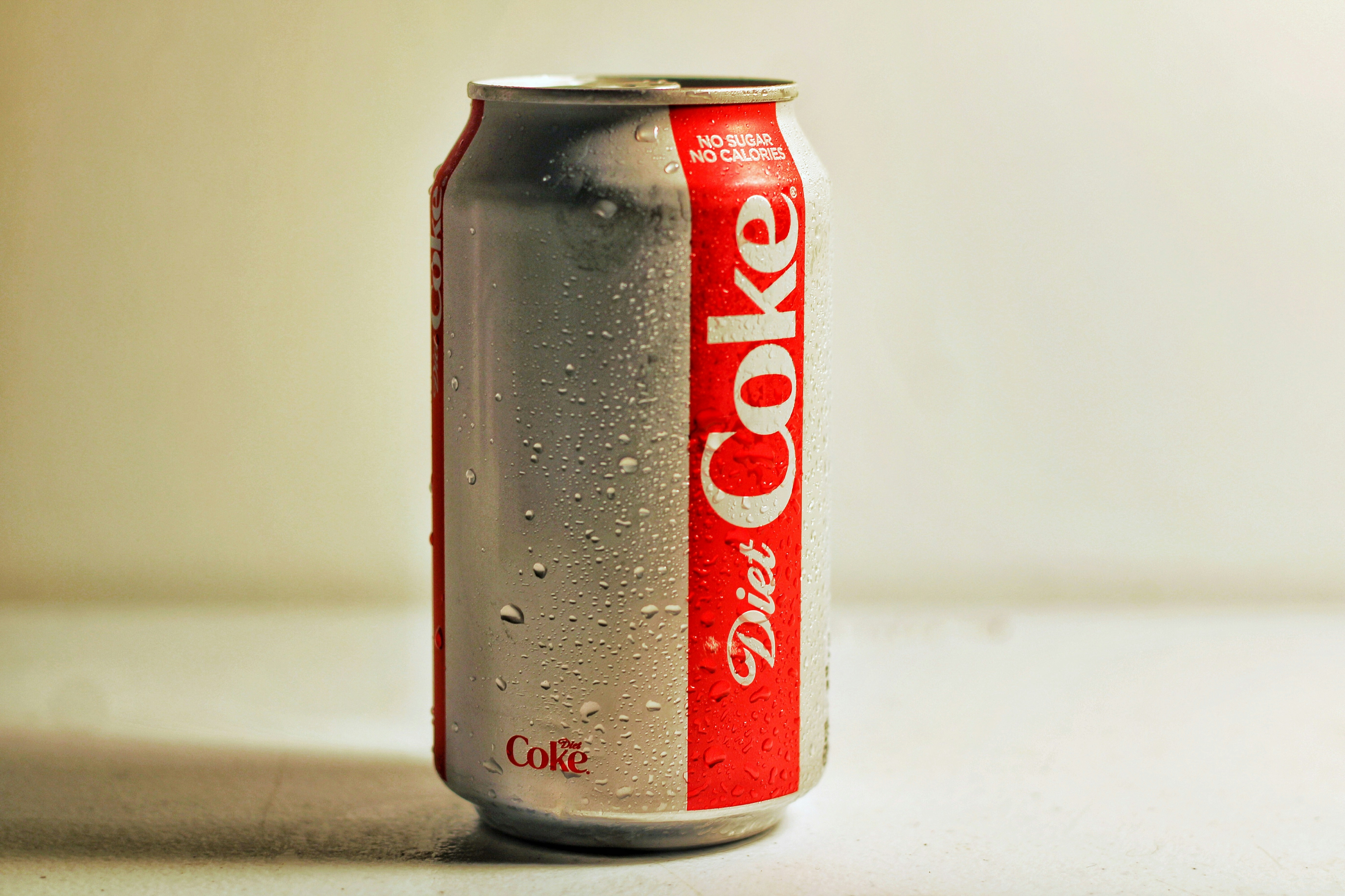 Diet Coke tin  with condensation droplets connected  its surface, sitting connected  a achromatic  background
