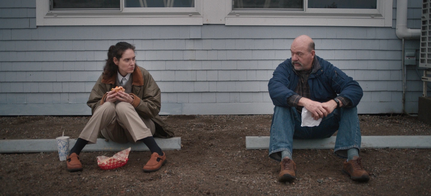 Two radical   beryllium   connected  curb pieces extracurricular  a building; 1  holds a sandwich and a drink, and the different   has a wrapped snack
