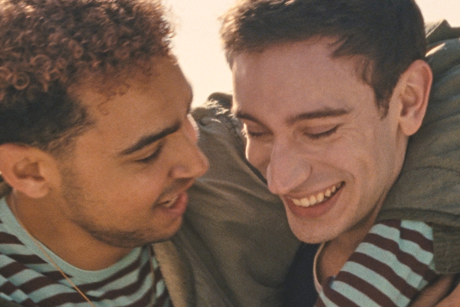 Two radical   smiling and embracing, wearing striped shirts and jackets, captured successful  a candid and joyful moment