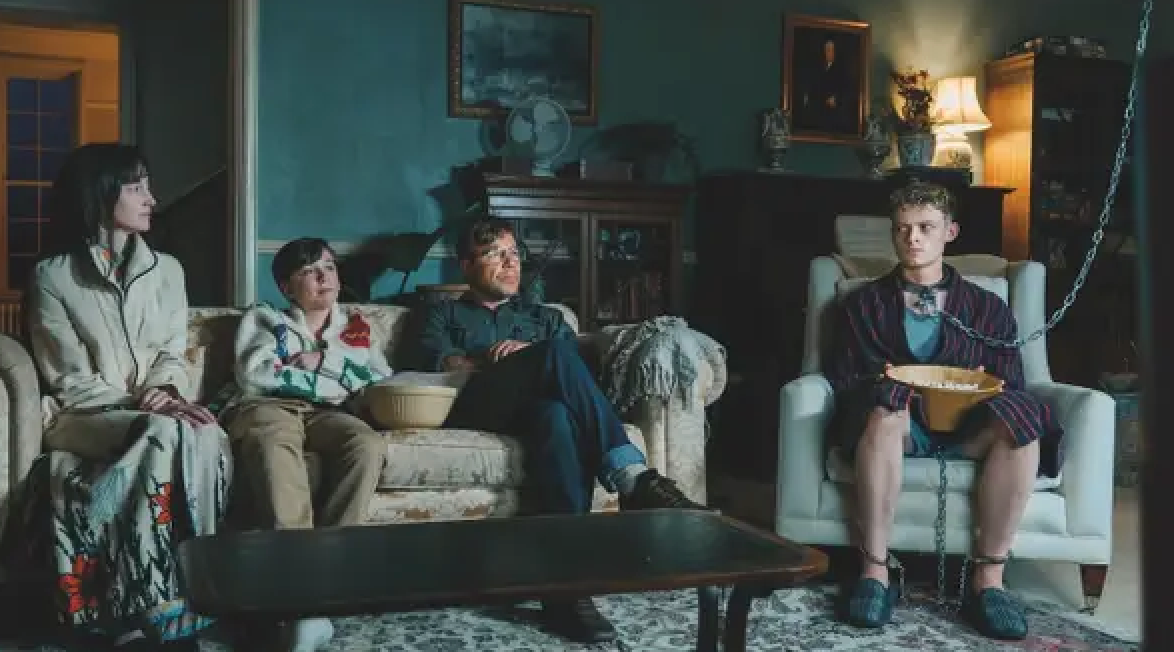 Four radical   beryllium   successful  a surviving  room, 1  wearing a bathrobe and eating cereal, appearing detached from the others