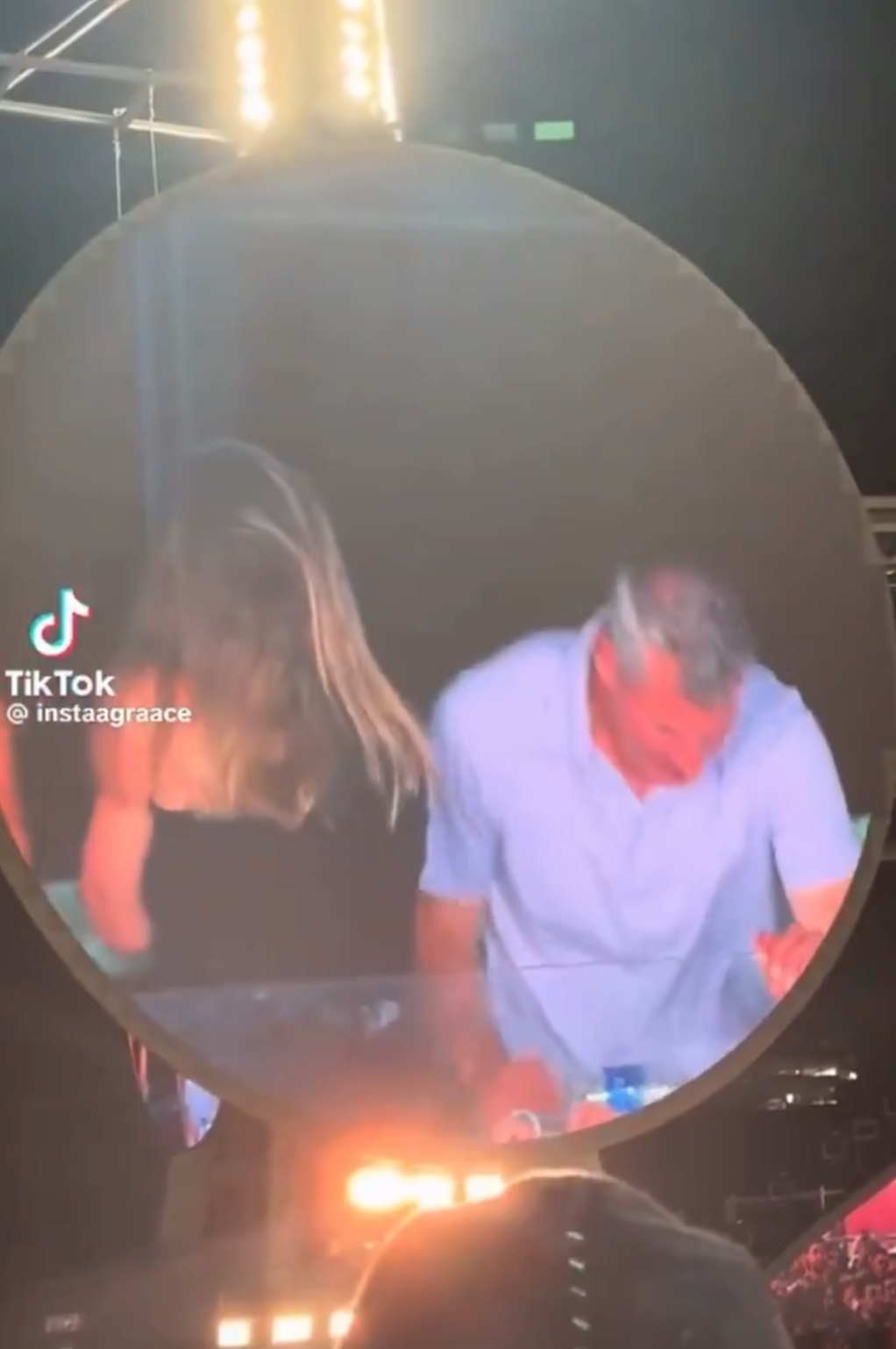 Two people captured on a screen at an event, laughing and enjoying themselves