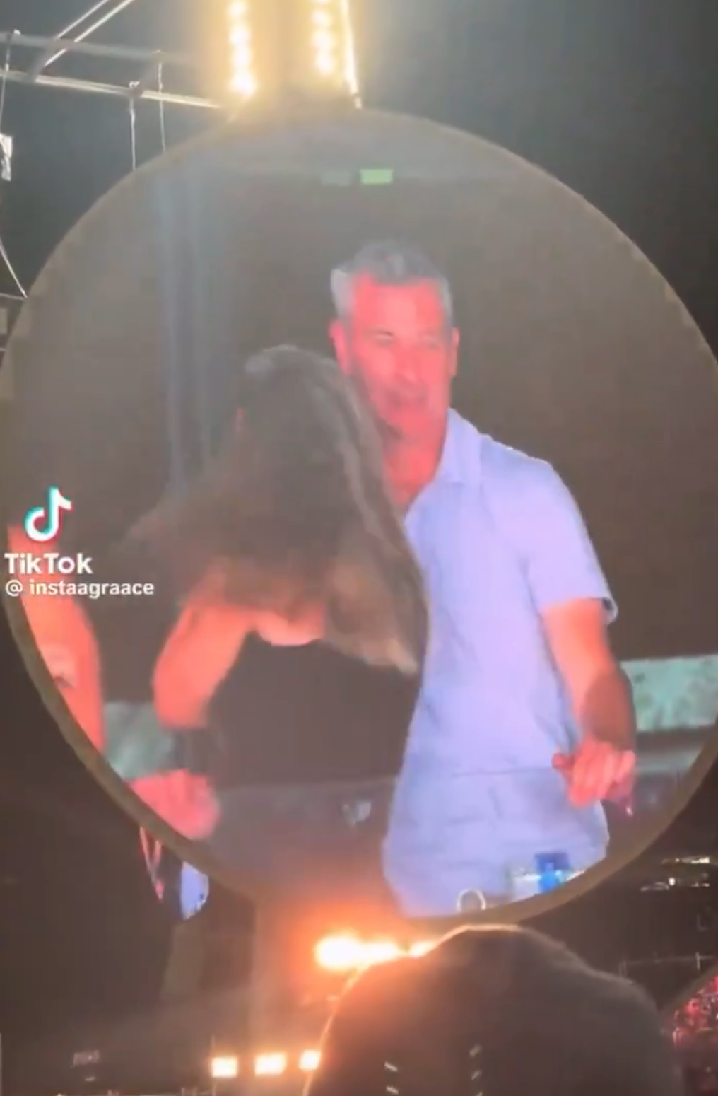 Man and woman dancing closely together, captured on a large screen at an event