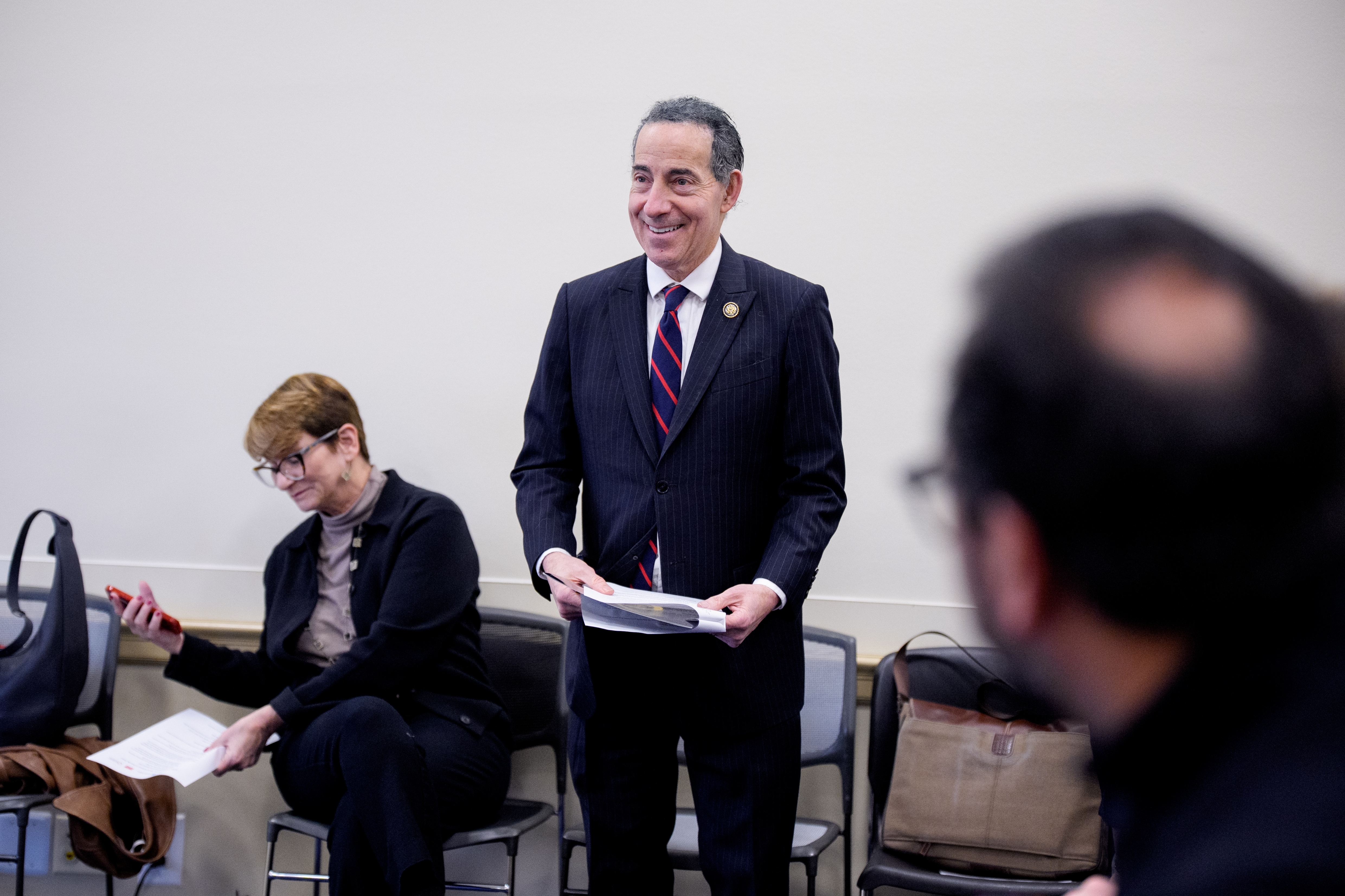 A antheral   successful  a suit   holds papers, lasting  successful  a country   with seated people