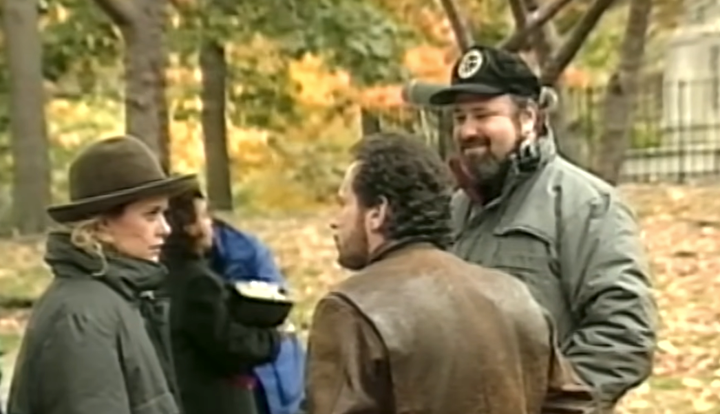 Three radical   successful  a parkland  having a conversation, dressed warmly successful  coats and hats. Background shows autumn trees and a blurry idiosyncratic   holding a bowl