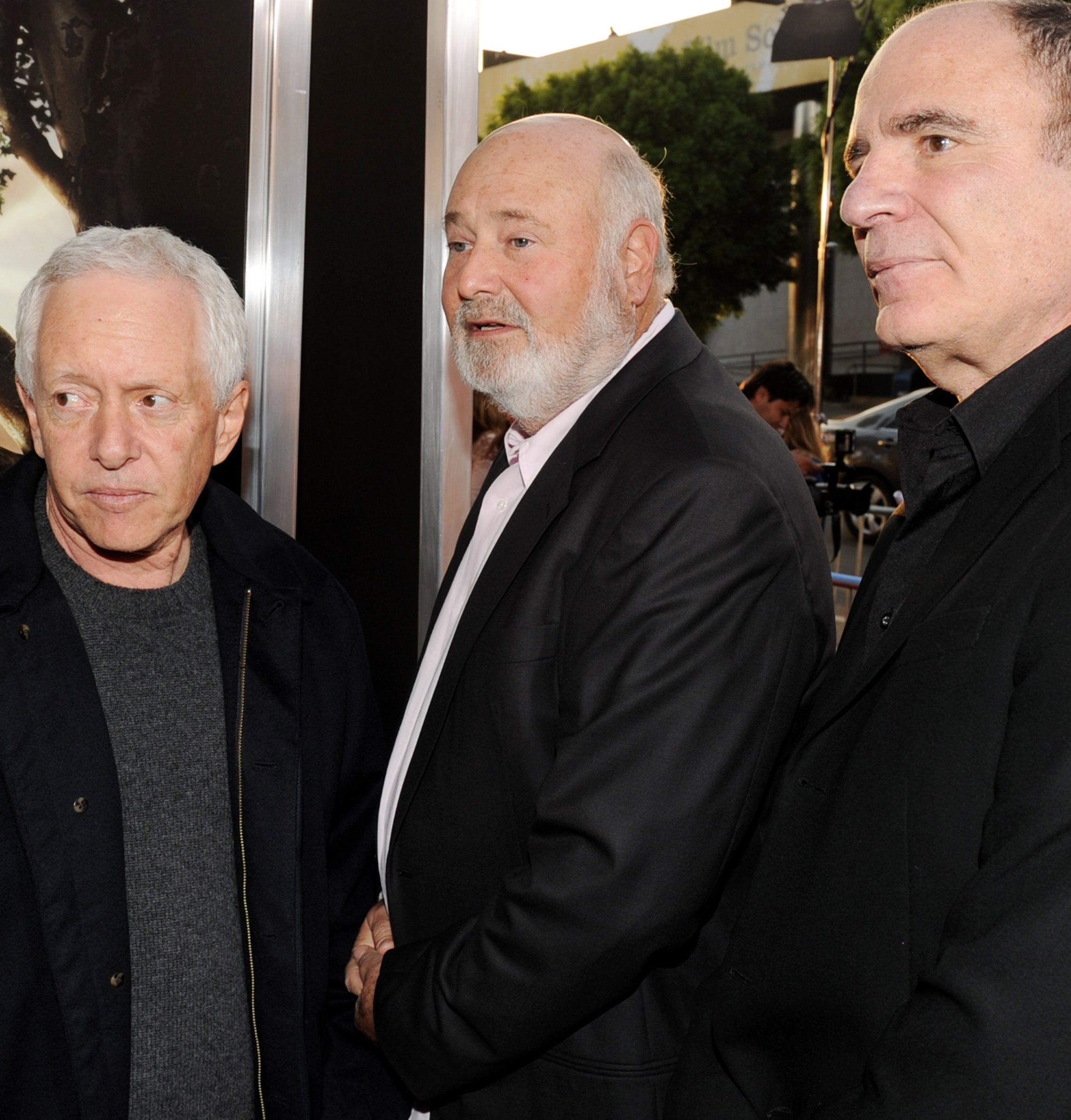 Three men successful  jackets basal   astatine  an event, looking to the side. A 4th  idiosyncratic   is partially disposable   down  them