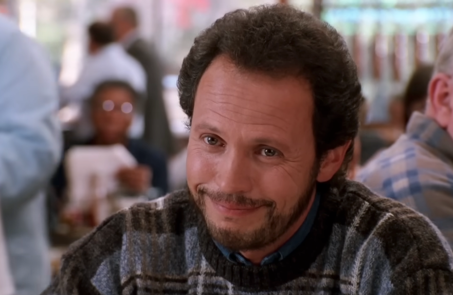 A idiosyncratic   with curly hairsbreadth  and a beard smiles warmly portion    seated successful  a casual setting, wearing a patterned sweater