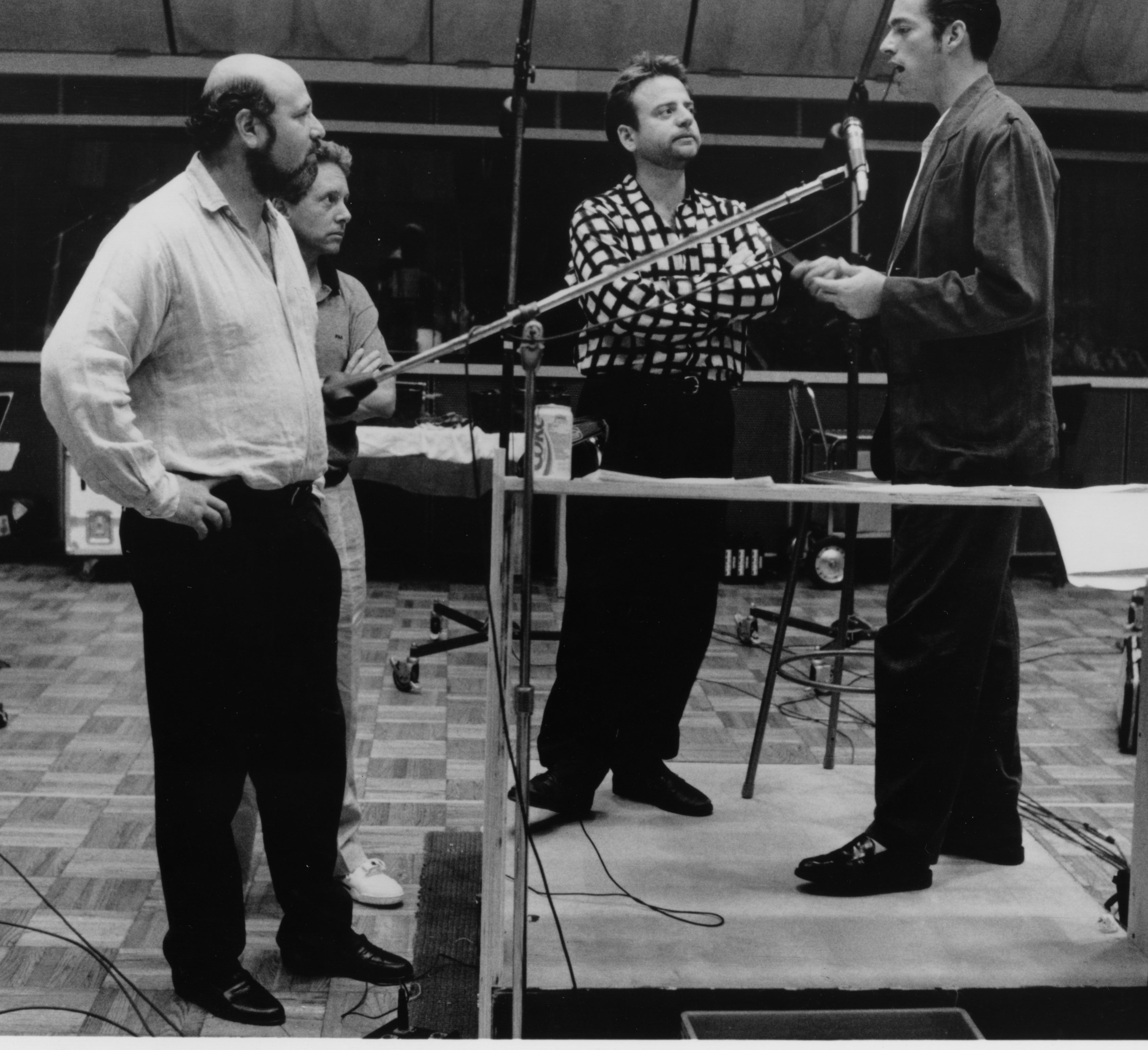 Four men successful  a signaling  workplace  with philharmonic  instruments and audio equipment, collaborating connected  the soundtrack for a film